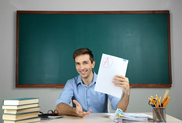 Junge Lehrerin sitzt im Klassenzimmer — Stockfoto