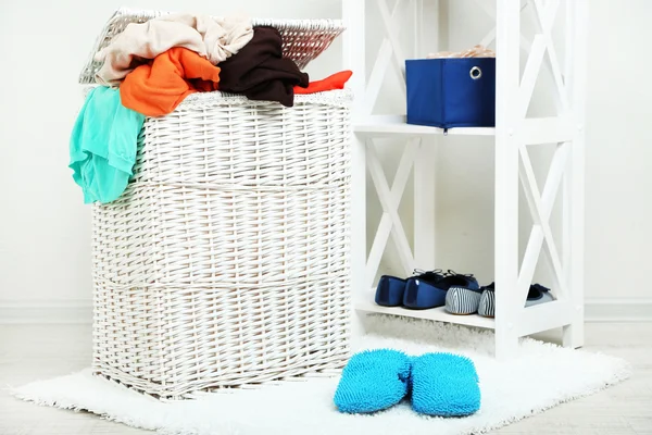 Panier à linge complet sur sol en bois sur fond intérieur de la maison — Photo