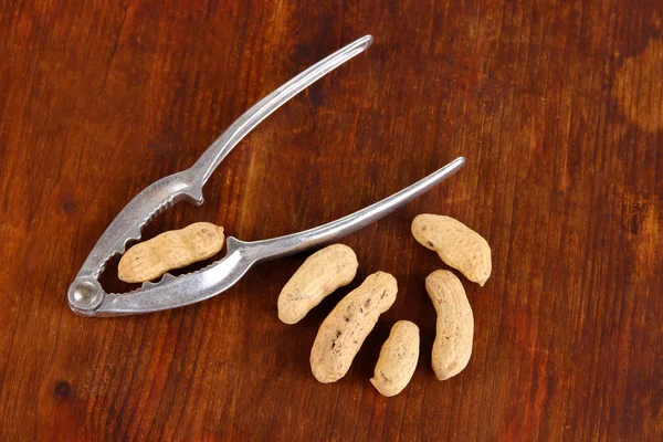 Cascanueces con tuercas en la mesa de madera de cerca — Foto de Stock