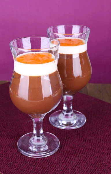 Postre de chocolate y caqui en la mesa sobre fondo púrpura —  Fotos de Stock