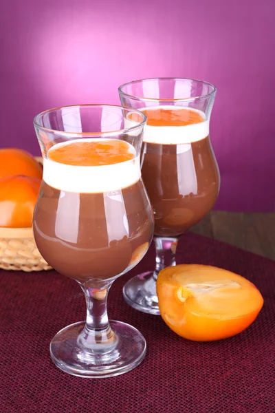 Dessert of chocolate and persimmon on table on purple background — Stock Photo, Image