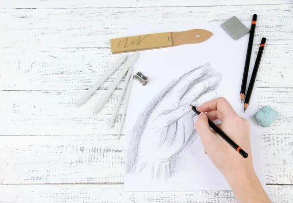 Mão desenha um esboço com materiais de arte profissional, na mesa de madeira — Fotografia de Stock