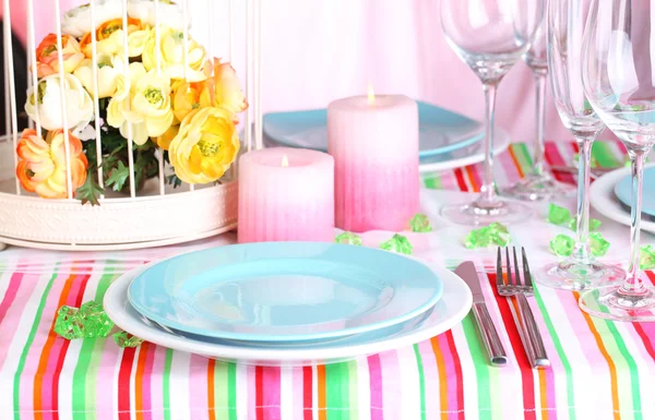 Стол с разноцветной посудой на фоне помещений — стоковое фото
