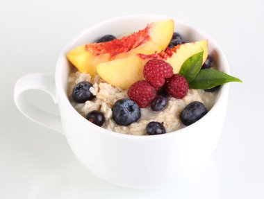 havermout in cup met bessen geïsoleerd op wit