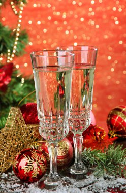 Yılbaşı süsleri ve parlak zemin üzerine iki şampanya bardağı kompozisyonu