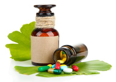 ginkgo biloba yaprakları ve beyaz izole hapları ile ilaç şişeleri
