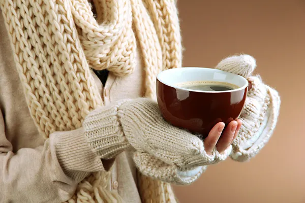 Female hands with hot drink, on color background — Stock Photo, Image