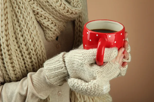 Mãos femininas com bebida quente, no fundo de cor — Fotografia de Stock