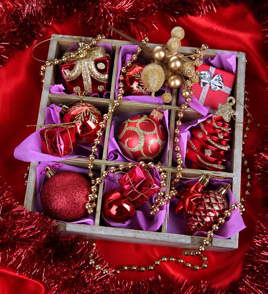 Jouets de Noël dans une boîte en bois sur fond lumineux — Photo