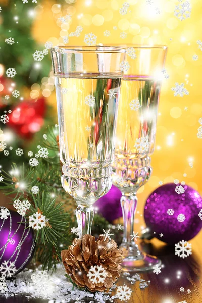 Композиція з різдвяними прикрасами та двома келихами шампанського на яскравому фоні — стокове фото