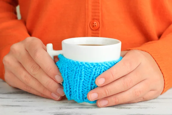 Cups with knitted things on it on wooden table close up — Stock Photo, Image