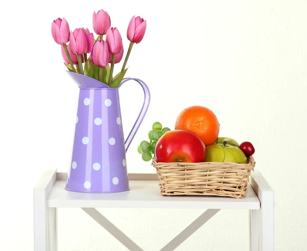 Květiny s ovocem na bílé police na šedou stěnu pozadí — Stock fotografie