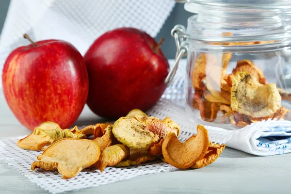 Gedroogde appels in glazen pot, op een houten achtergrond kleur — Stockfoto