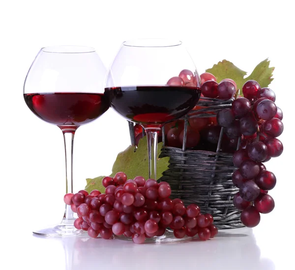 Kieliszki z czerwonego wina i moszczu winogronowego w wiklinowym koszu na białym tle — Zdjęcie stockowe