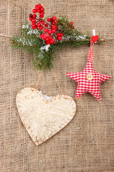 Decorative heart and star on rope, on burlap background — Stock Photo, Image