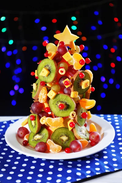 Árbol de Navidad de frutas en la mesa sobre fondo oscuro —  Fotos de Stock