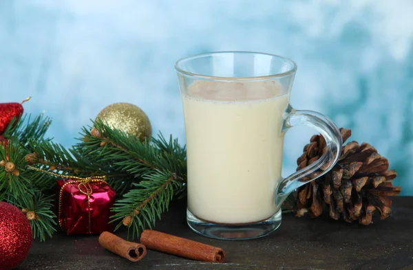 Coupe de lait de poule avec branches de sapin et décorations de Noël sur table sur fond lumineux — Photo