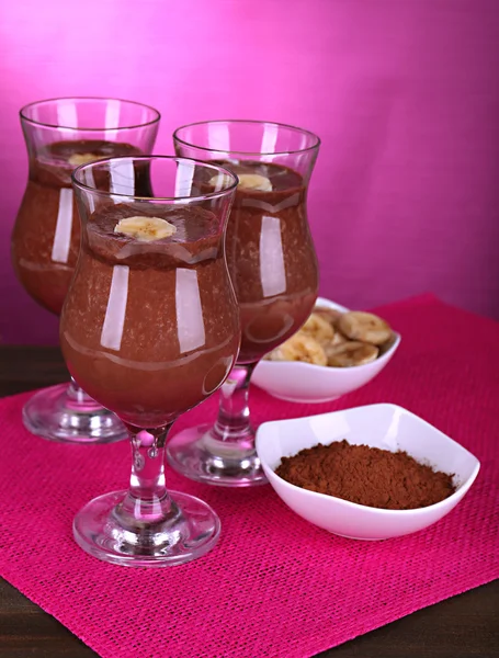 Coquetéis com banana e chocolate na mesa em fundo roxo — Fotografia de Stock