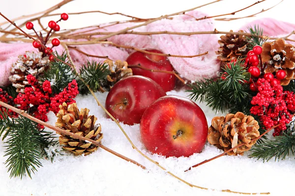 Manzanas rojas con ramas de abeto y bufanda de punto en la nieve de cerca — Foto de Stock