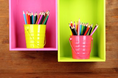 kovaları raf ahşap arka plan üzerinde renkli kalem