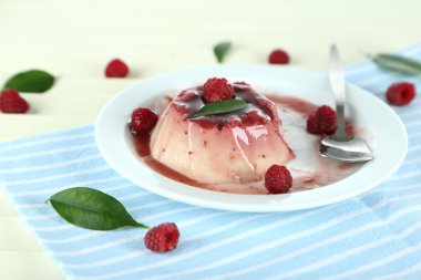 Panna cotta ahşap zemin üzerinde frambuaz sos ile