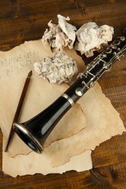 buruşuk kağıt topları ile müzik sayfaları ve klarnet ahşap zemin üzerinde