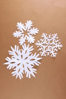 kahverengi zemin üzerinde güzel kağıt kar taneleri