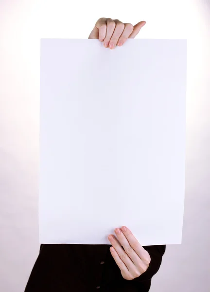 Žena držící prázdné podepsat před její tvář, izolované na bílém — Stock fotografie