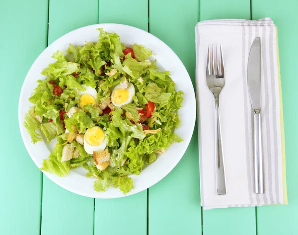 Salada Caesar na placa branca, na cor de fundo de madeira — Fotografia de Stock