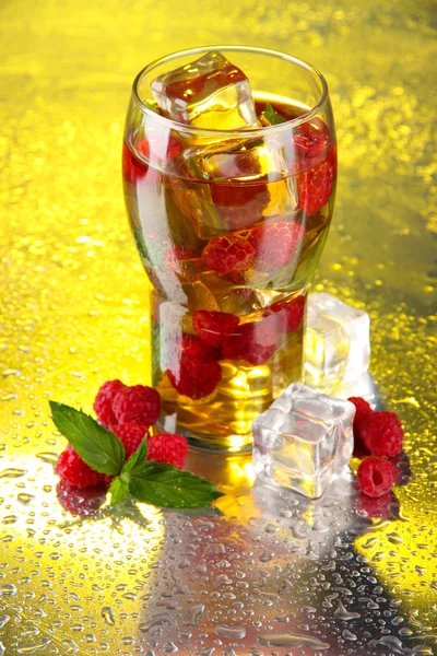 Iced tea with raspberries and mint on bright background — Stock Photo, Image