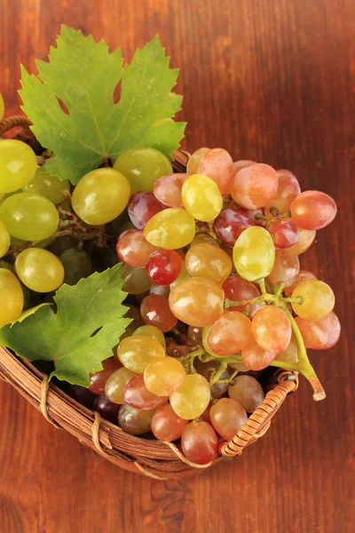 Raisin doux mûr dans le panier sur fond en bois — Photo