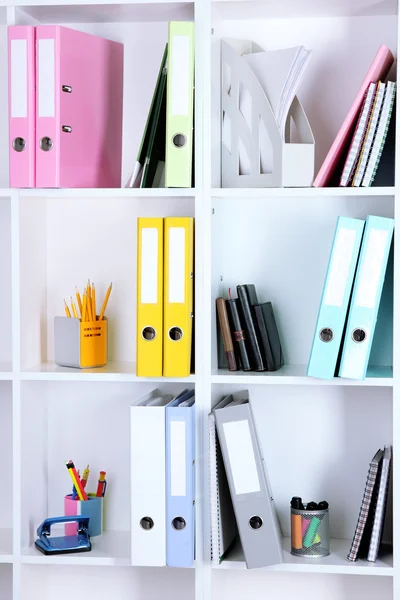 Prateleiras de escritório branco com pastas e artigos de papelaria diferentes, close-up — Fotografia de Stock