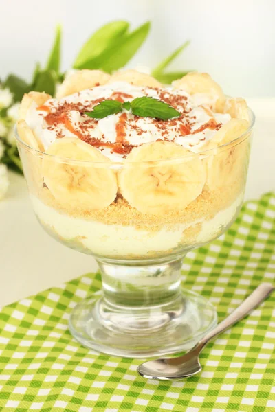 Delicious dessert with banana and caramel on table on light background — Stock Photo, Image