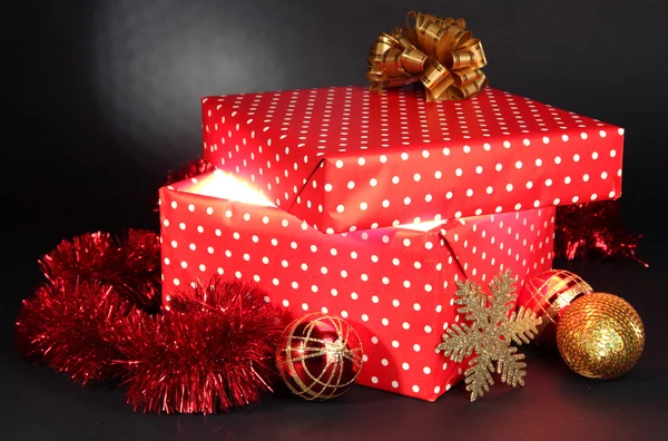 Caja de regalo con luz brillante sobre fondo gris oscuro — Foto de Stock