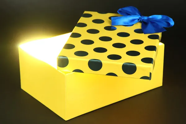 Geschenkbox mit hellem Licht auf dunkelgrauem Hintergrund — Stockfoto