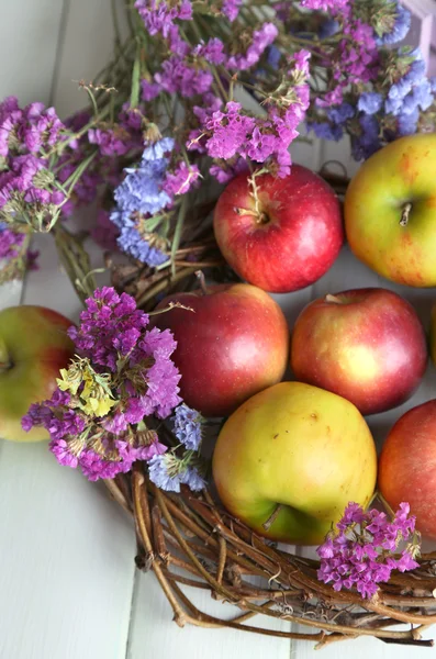 Saftige Äpfel in Schachtel auf weißem Holztisch — Stockfoto