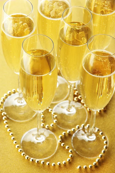 Bicchieri con champagne su sfondo lucido — Foto Stock