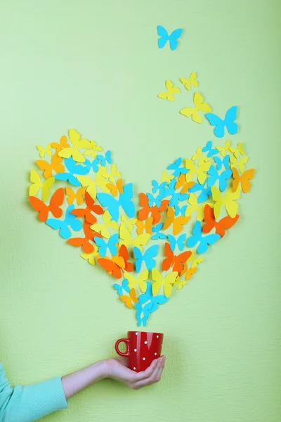 Mariposas de papel vuelan fuera de la taza sobre fondo de pared verde — Foto de Stock