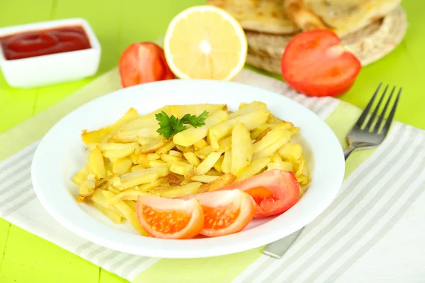 Patatas fritas en plato sobre mesa de madera primer plano —  Fotos de Stock