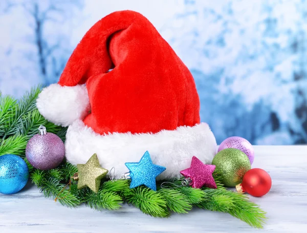 Samenstelling met santa claus rode hoed en Kerst decoraties op lichte achtergrond — Stockfoto
