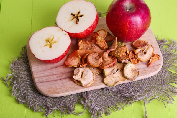 Manzanas secas, sobre tabla de cortar, sobre fondo de madera de color —  Fotos de Stock