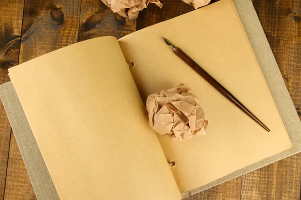 Boules de papier froissées avec cahier et stylo à encre sur fond en bois — Photo