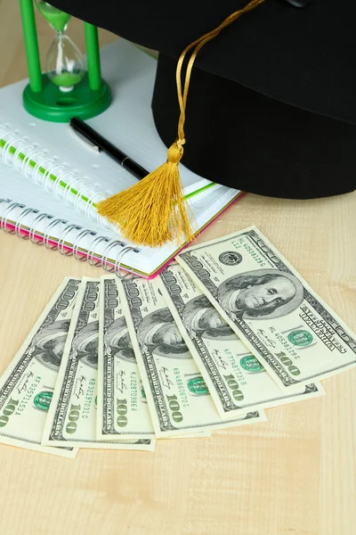 Гроші на випускні або навчання на дерев'яному столі крупним планом — стокове фото