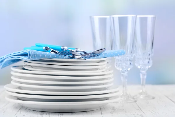 Clean dishes on wooden table on light background — Stock Photo, Image