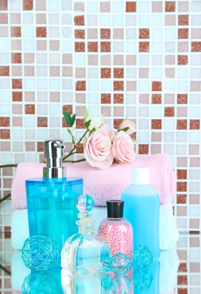 Cosmétiques et accessoires de bain sur fond de carreaux de mosaïque — Photo