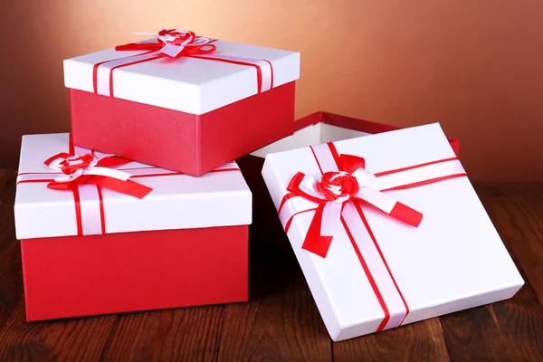 Beautiful gift boxes on table on brown background