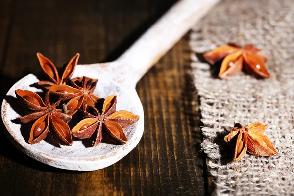 Star anise in wooden spoon, on wooden background — Stock Photo, Image