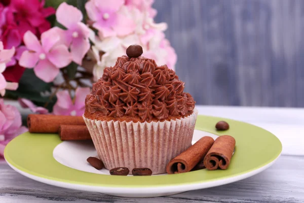 Leckere Cupcake mit Buttercreme, auf Teller, auf farbigem Holzhintergrund — Stockfoto