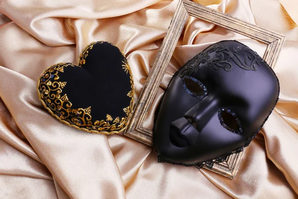 Decorative black heart and mask, on color fabric — Stock Photo, Image