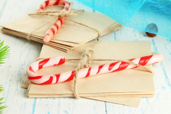 Bastoncini di zucchero natalizio e lettere per Babbo Natale, su sfondo di legno a colori — Foto Stock